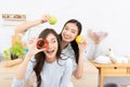 Asian two women wearing sportswear eat healthy foods in kitchen. Young beautiful girl happy and enjoy eating fruits healthy Royalty Free Stock Photo