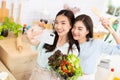 Asian two women wearing sportswear eat healthy foods in kitchen. Young beautiful girl happy and enjoy eating fruits healthy Royalty Free Stock Photo