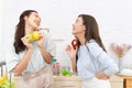 Asian two women wearing sportswear eat healthy foods in kitchen. Young beautiful girl happy and enjoy eating fruits healthy Royalty Free Stock Photo