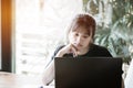 Asian University or college students studying together with tablet,laptop and documents paper for report near windows in classroom Royalty Free Stock Photo