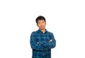 An Asian untidy man in blue plaid shirt is crossing his arms and looking down to the floor thinking of something