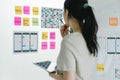 Asian ux designer evaluating app prototypes with color swatches. Royalty Free Stock Photo