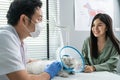 Asian veterinarian examine cat during appointment in veterinary clinic. Professional vet doctor male sit on table with stethoscope