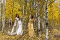 Asian Vietnamese bride with mother in traditional Vietnamese wedding dresses in the yellow autumn aspen trees of Colorado