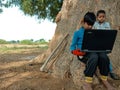 Asian village kids operating laptop at natural background in india January 2020 Royalty Free Stock Photo