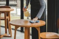 Asian waitress staff service woman in apron cleaning table with disinfectant spray for protect infection coronavirus covid-19 in Royalty Free Stock Photo