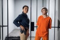 Asian warden and a female prisoner in a high-security prison stand in front of an open cell.