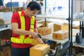 Asian warehouse man worker with computer and barcode scanner in warehouse scan at box prepare deliverly to customer