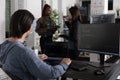 Asian web developer analyzing compiling code looking at computer and laptop