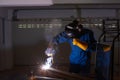 Asian welder wearing helmet welding job with spark in workplace