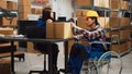 Asian wheelchair user working in warehouse space