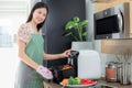 Asian wife cooking fries chicken by use her electric fryer in her kitchen at home Royalty Free Stock Photo