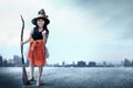 Asian witch girl with the magic broom on the urban street Royalty Free Stock Photo