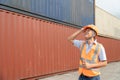 asian wman Engineer with note clipboard and asian man Supervisor in Hard Hats and Safety Vests Stand in Container Terminal. Royalty Free Stock Photo