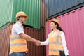 asian wman Engineer with note clipboard and asian man Supervisor in Hard Hats and Safety Vests Stand in Container Terminal. Royalty Free Stock Photo