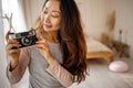 Asian woma taking pictures with old film camera. woman Photographer making pictures with retro camera having fun at home. Royalty Free Stock Photo