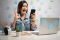 Asian woman angry looking at smart phone reading news and shouting at home office. WFH. Work from home. Prevention Coronavirus Royalty Free Stock Photo