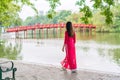 Asian woman in Ao Dai (traditional Vietnamese dress) sightseeing at the Red Bridge in Hoan Kiem Lake, Hanoi, Vietnam Royalty Free Stock Photo