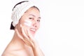 Asian woman apply cream, lotion to beautiful skin on cheek after bath. Young woman showing cream or moisturizer on face. Smiling A Royalty Free Stock Photo