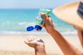 Asian woman apply sun screen on to her hand on tropical beach. Girl applying sun block to her skin. summer and beach concept Royalty Free Stock Photo