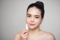 Asian woman applying hygienic lip balm over grey background Royalty Free Stock Photo