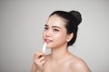 Asian woman applying hygienic lip balm over grey background Royalty Free Stock Photo