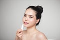 Asian woman applying hygienic lip balm over grey background Royalty Free Stock Photo