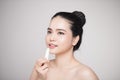 Asian woman applying hygienic lip balm over grey background Royalty Free Stock Photo