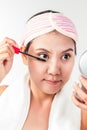 Asian woman applying mascara makeup on eyes by brush Royalty Free Stock Photo