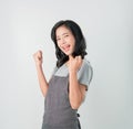 Asian woman in apron and standing with amazed for success and looking forward on gray background. Small business.