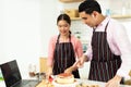 Asian woman and Arab man as Young adult couple learn how to bakery cooking cake online course kitchen. Diverse Family video to Royalty Free Stock Photo