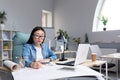 Asian woman architect designer wearing glasses working at desktop computer and drawing with pencil Royalty Free Stock Photo