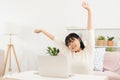 Asian woman arms stretched and working at home. Asia teen using laptop while sitting in living room at morning Royalty Free Stock Photo