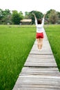 Asian woman arms up on wood walk way Royalty Free Stock Photo