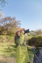 Asian woman in hat taking photos.