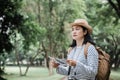 Asian woman backpack traveler use map when traveling at rain for