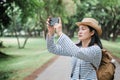 Asian woman backpack traveler use mobile take photo when traveling at rain forest.Holiday vacation Royalty Free Stock Photo