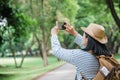 Asian woman backpack traveler use mobile take photo when traveling at rain forest.Holiday vacation Royalty Free Stock Photo