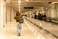 Asian woman with backpack walking to the gate in airport terminal.