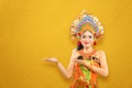 Asian woman with Balinese traditional dance costume showing something