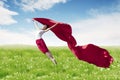 Asian woman ballerina holding red fabric making a big jump on blossom meadow. Royalty Free Stock Photo