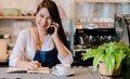Asian woman Barista calling with customer at front counter occupation Royalty Free Stock Photo