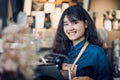 Asian woman barista making hot coffee with machine at counter bar and smile at camera in cafe restaurant,Food and drink service Royalty Free Stock Photo