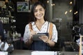 Asian women Barista smiling and using coffee machine in coffee s