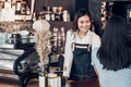 Asian woman barista wear jean apron holding coffee cup served to customer at bar counter with smile emotion,Cafe restaurant Royalty Free Stock Photo