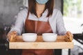 Asian woman barista wearing face mask working in coffee shop Royalty Free Stock Photo