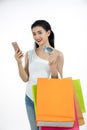 Asian women and Beautiful girl is holding shopping bags and using a smart phone and smiling while doing shopping online with Royalty Free Stock Photo