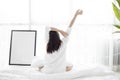 Asian woman Beautiful young smiling woman sitting on bed and stretching in the morning at bedroom after waking up in her bed full Royalty Free Stock Photo