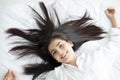 Asian woman Beautiful young smiling woman sitting on bed and stretching in the morning at bedroom after waking up in her bed full Royalty Free Stock Photo