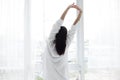 Asian woman Beautiful young smiling woman sitting on bed and stretching in the morning at bedroom after waking up in her bed full Royalty Free Stock Photo